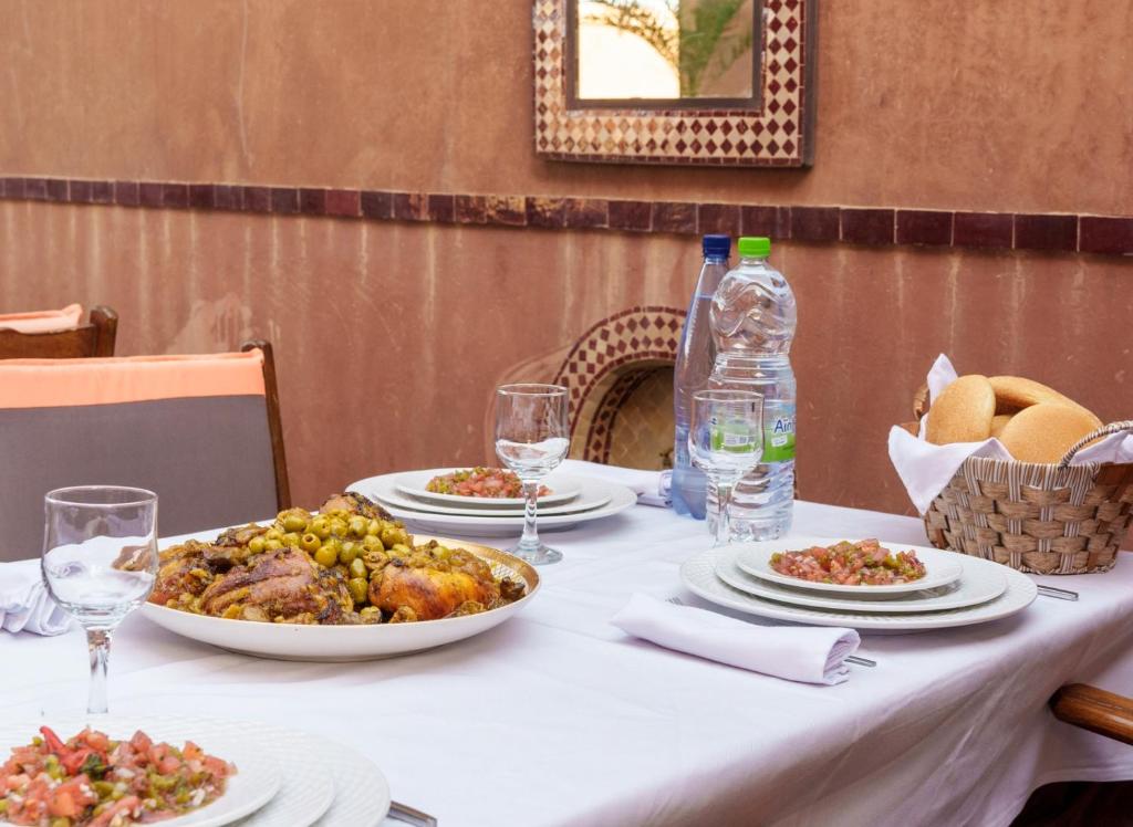 Festin marocain d'hôtes sur le patio avec poulet rôti aux olives et salades marocaines
